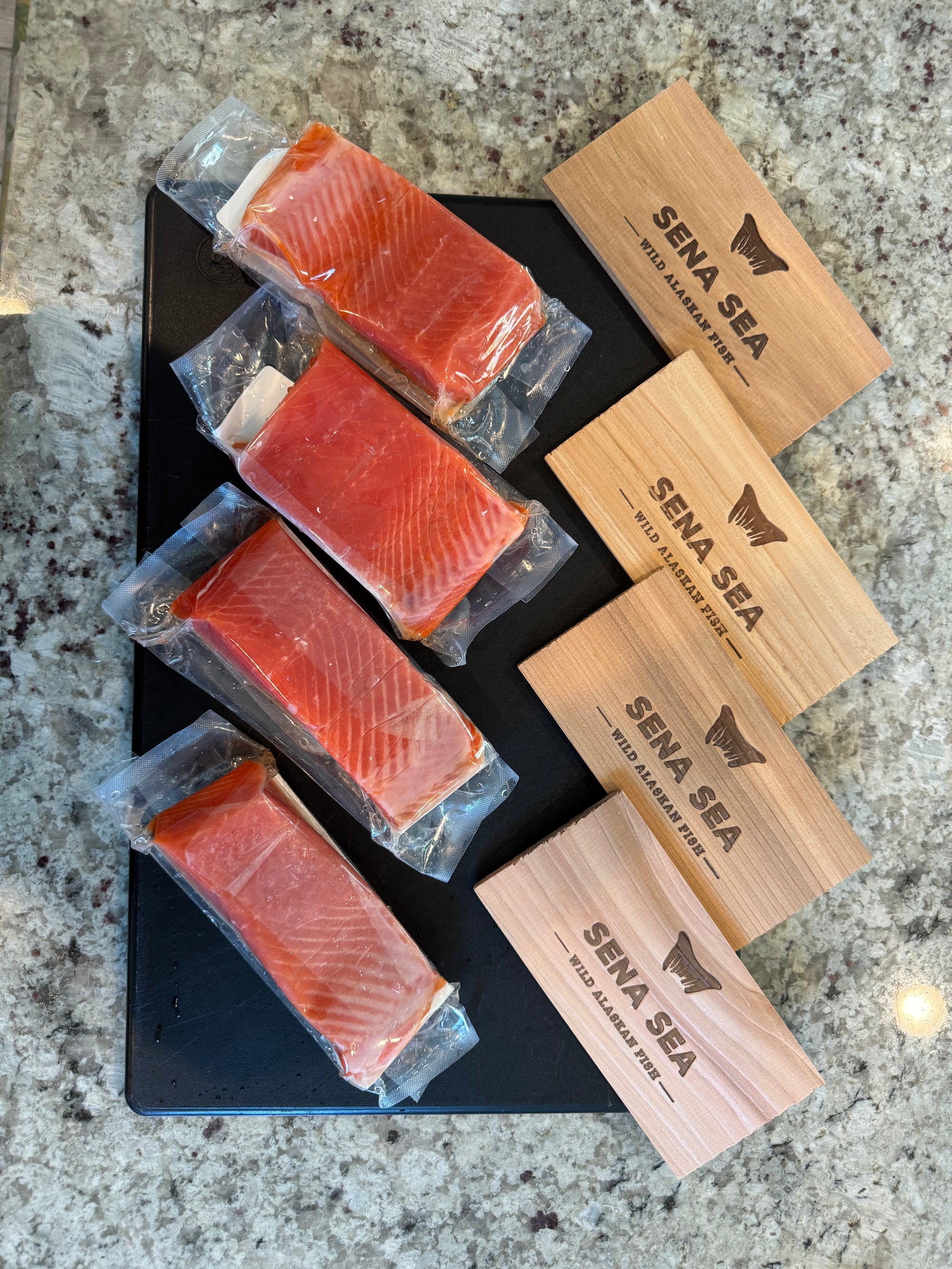 Packaged salmon fillets with 'Sena Sea' branded cedar planks.