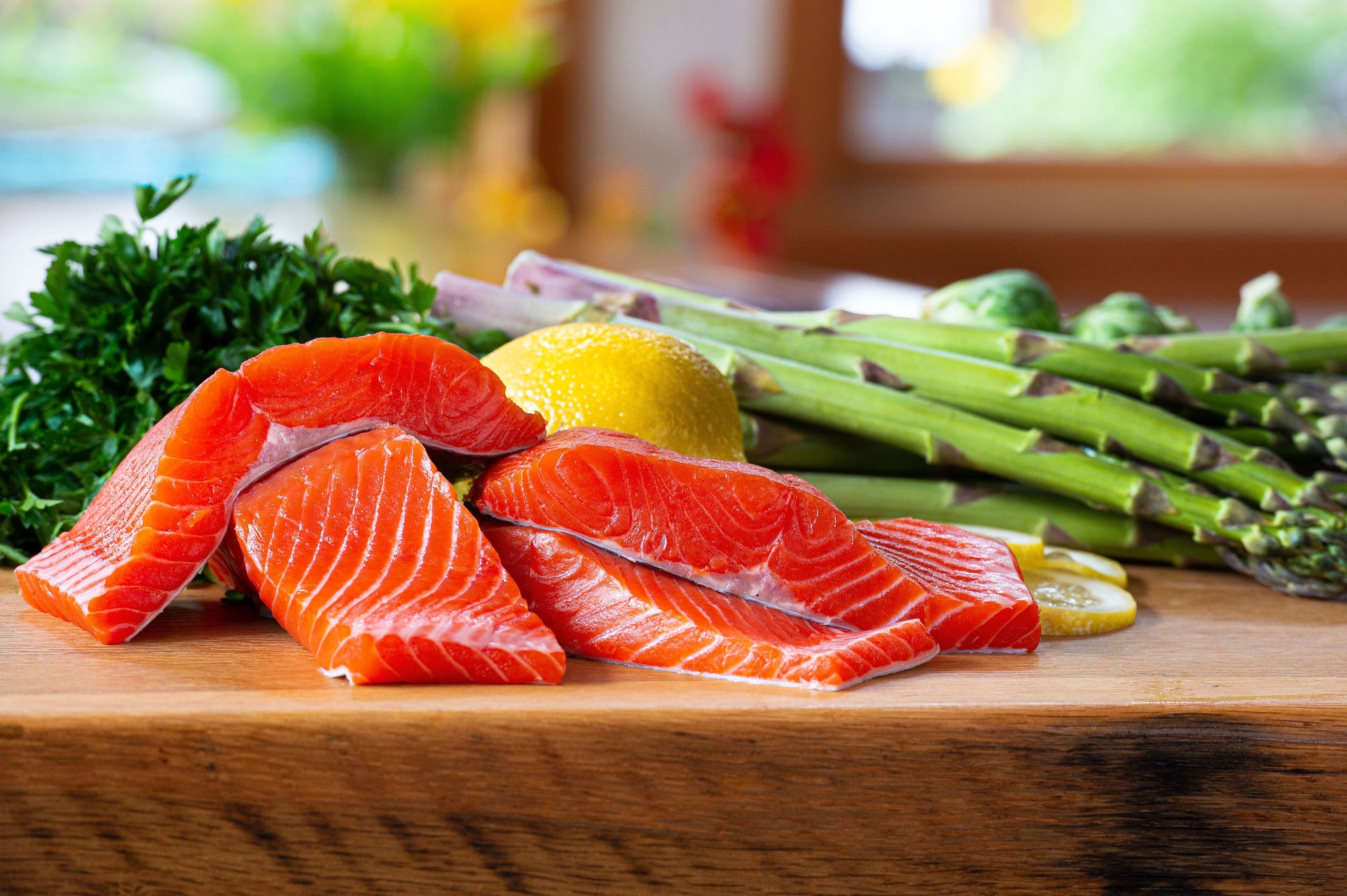 Sliced Wild Caught Copper River Sockeye Salmon with lemon and asparagus