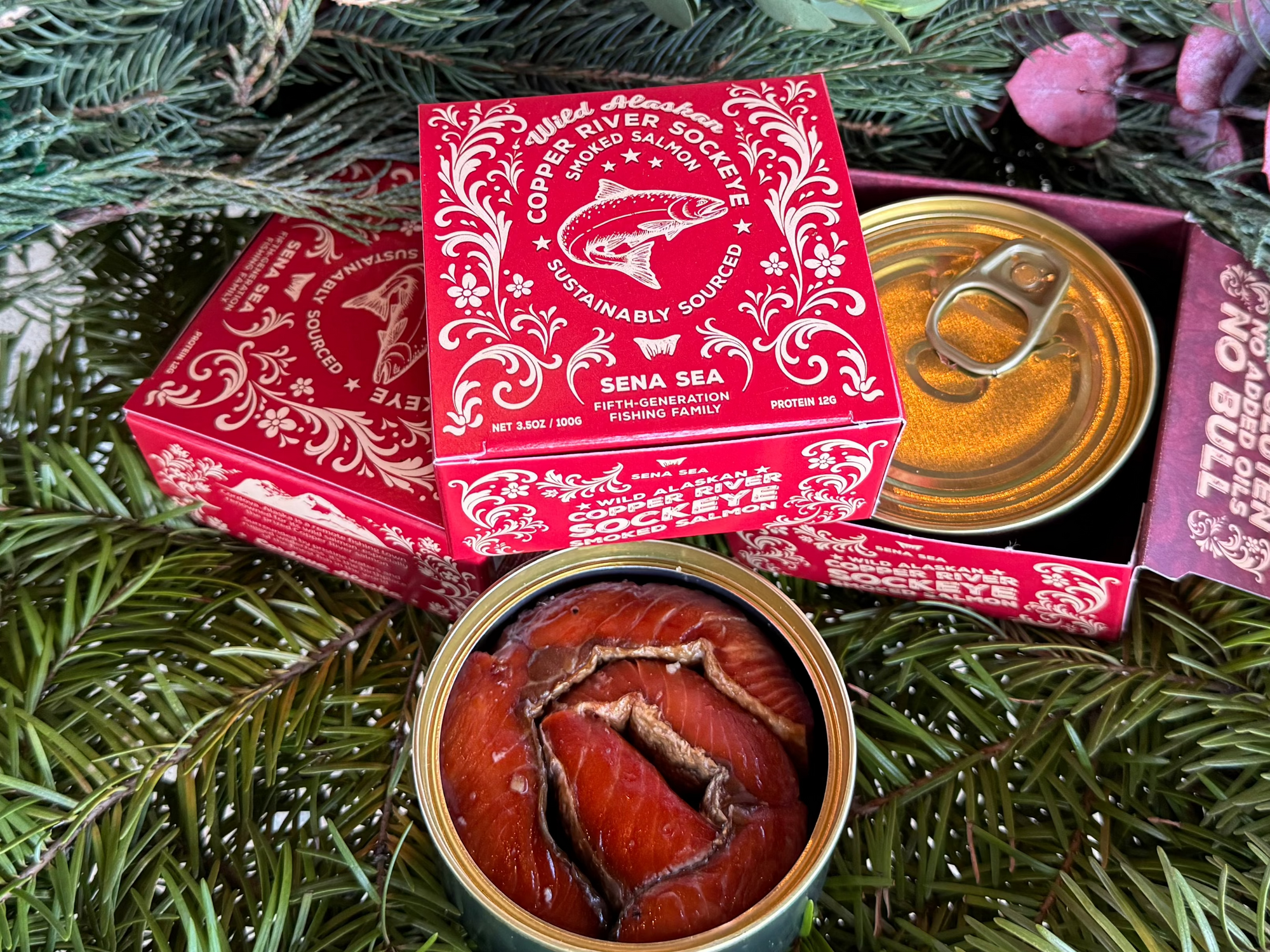Two small red boxes of smoked copper river sockeye on a bed of greenery