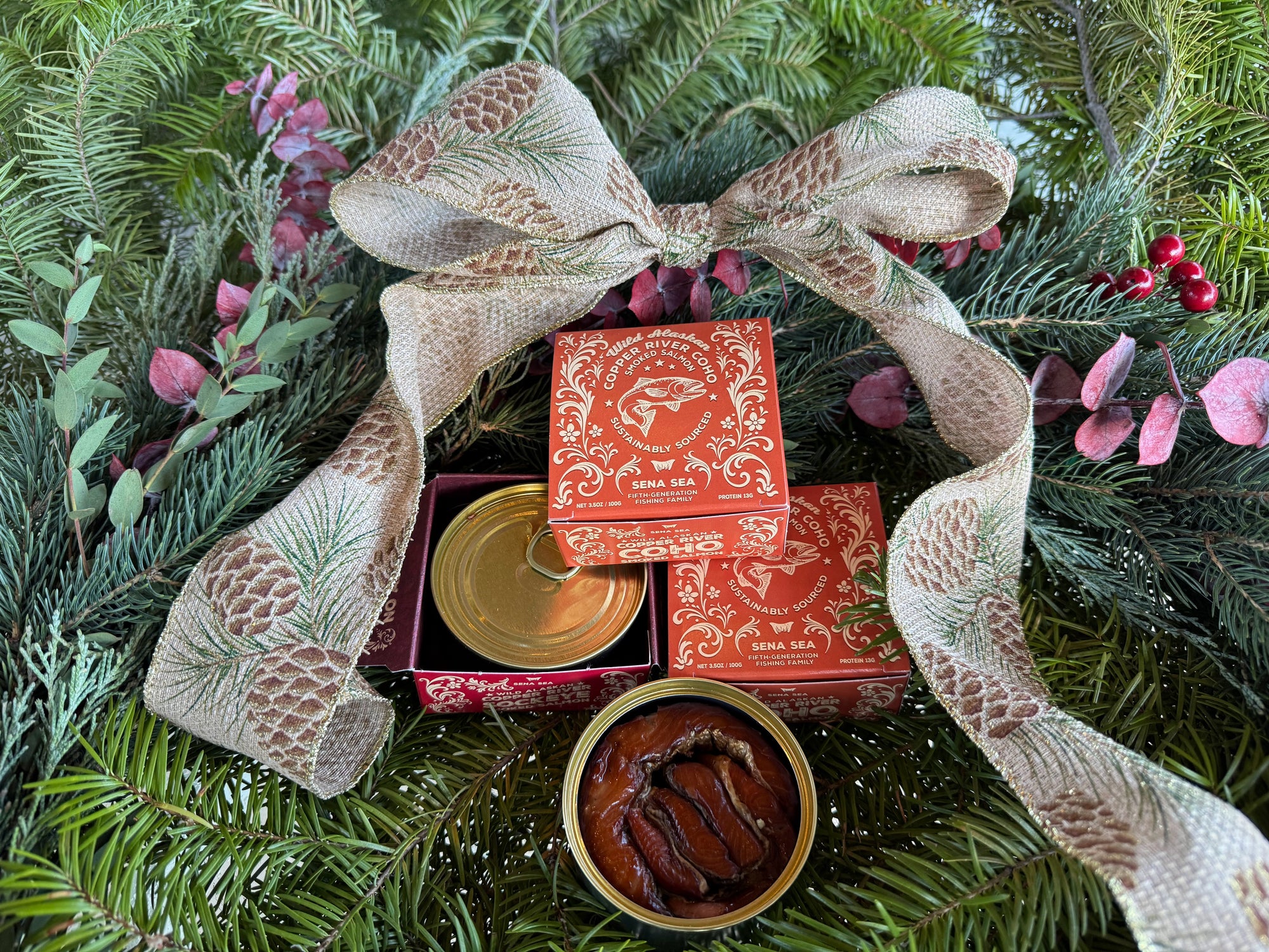 smoked Copper River coho salmon in an orange box with a festive greenery background