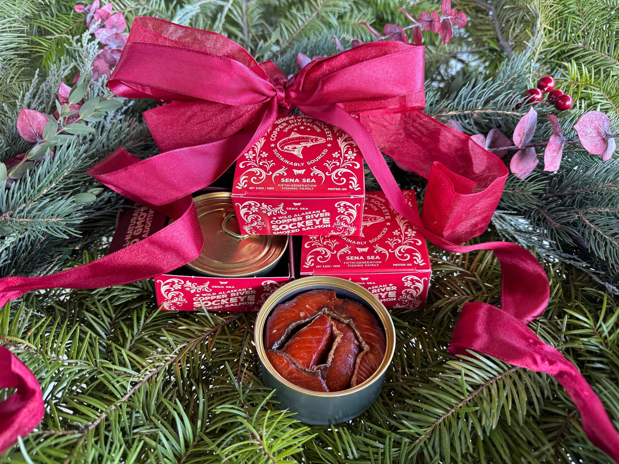 Red gift box of smoked Copper River sockeye with a red bow on a Christmas wreath