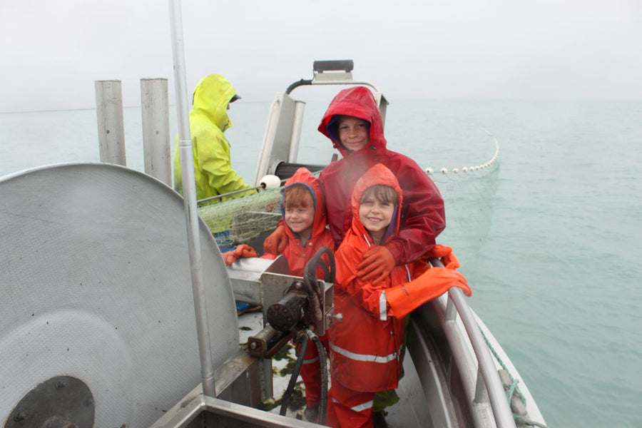 The Wheeler kids dressed in bright rain suits on the Alrita in Alaska