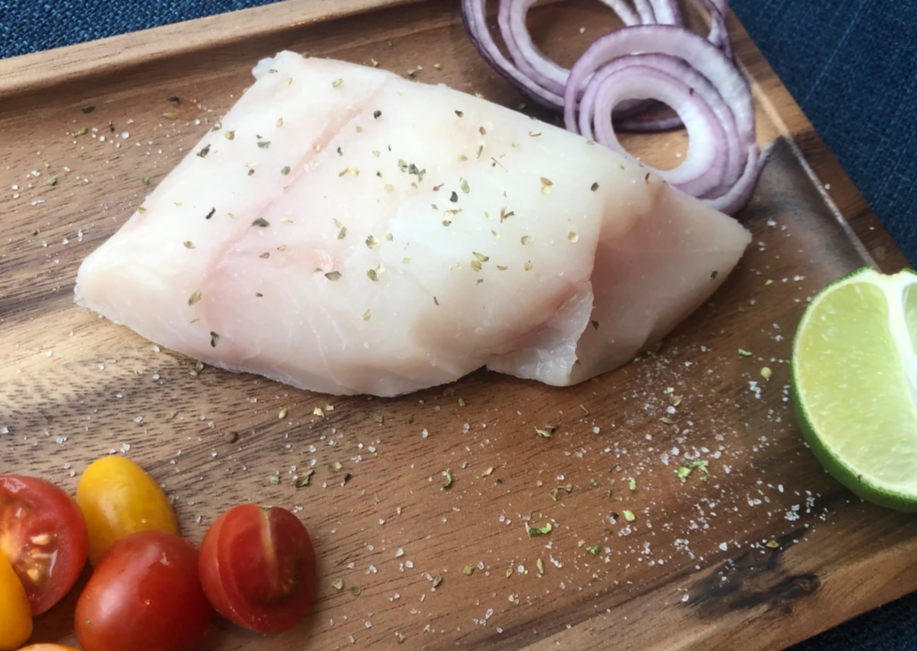 Wild caught lingcod fillet seasoned on a cutting board